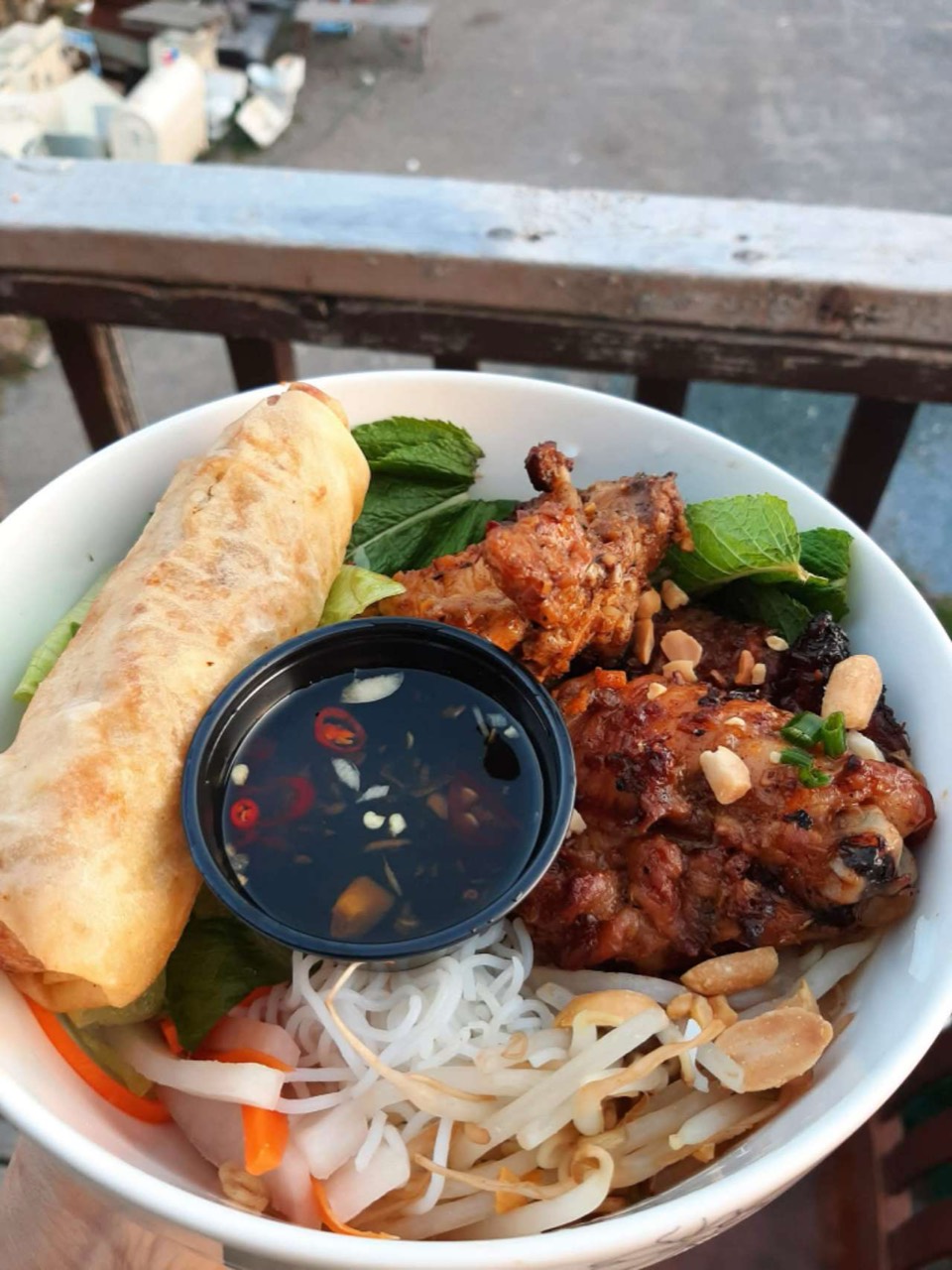 Grilled chicken on noodles with vegetables and sauce.