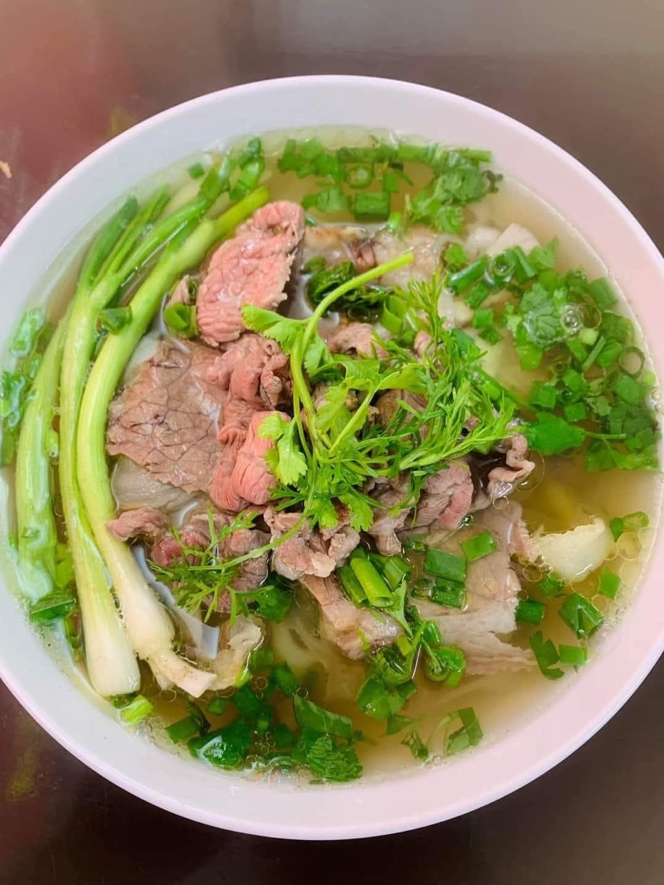 Pho beef with herbs and greens.